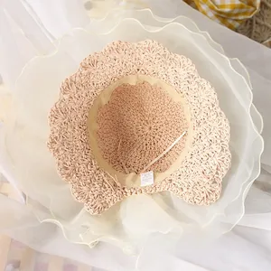 Detail of baby straw hat featuring woven texture and soft white wavy tulle brim details