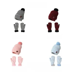 Detailansicht von vier farbig gestreiften Strickmützen und Handschuhen Sets mit Bommel