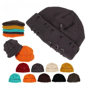 Detail of distressed knitted beanie showing metal pins, three rings and 10 color options