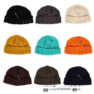 Knitted beanies with pin and ring details displayed in nine different color variants