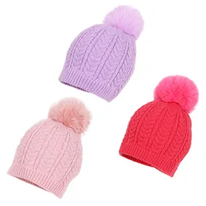 Trois bonnets en tricot torsadé pour enfants avec pompons en lilas, rose et magenta