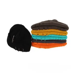 Detail of knitted beanie featuring metal rings, pins and distressed ripped street style