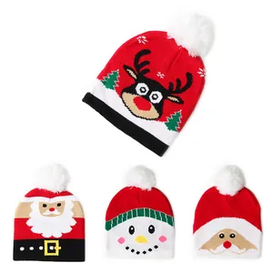 Gebreide kerstmutsen voor kinderen met rendier en pompons in rood en wit design