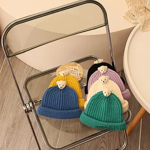 Detailansicht verschiedener Farben warmer Strickmützen mit niedlichen Bärenornamenten