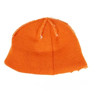 Detail of bright orange knit beanie featuring unique white decorative contrast stitching