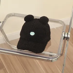 Close-up of black teddy fleece kids baseball cap with cute round ears and patch detail