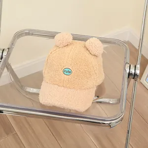 Detail of lamb wool kids baseball cap featuring cute ears and blue 'cute' embroidery