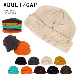 Distressed knit beanie featuring metal safety pins and rings in multiple colors