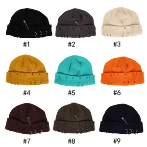 Distressed knit beanies with metal rings and safety pins in nine assorted colors