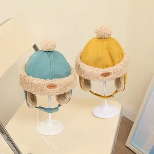 Detail view of kids fleece-lined aviator hats in blue and yellow with ear flaps