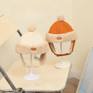 Detail of warm winter trapper hat for kids featuring faux suede and cozy sherpa lining