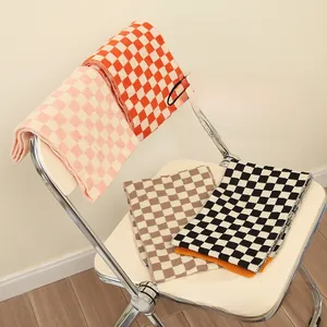 Close-up of checkered knit baby scarves in orange, pink, coffee, and black colors