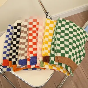 Detail view of multi-color checkerboard knit scarves for babies in six different soft colors