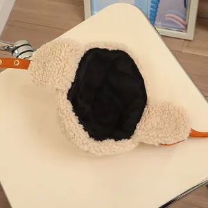 Detail of beige fleece aviator hat showing black lining and orange adjustment strap