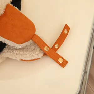 Detail of warm lamb wool lining and suede strap with gold metal snaps on winter aviator hat