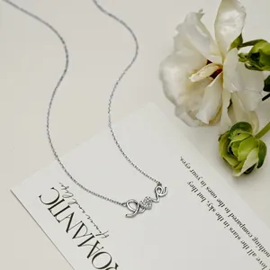 Macro detail of silver Love necklace pendant with heart-shaped O and micro zircons