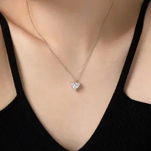 Gros plan d'un pendentif cœur étincelant en zircon sur une chaîne en argent fin