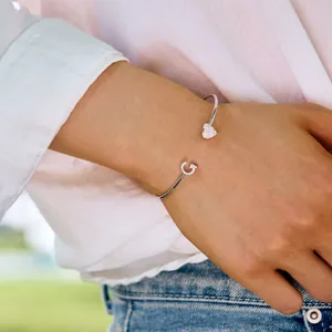 Detail eines S925 Silberarmbands mit Zirkon-Herz und Buchstabe C an einem Frauenhandgelenk