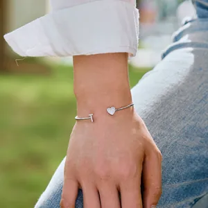 S925 Sterling Silber Armreif mit Zirkonia-T und Herzform an einem Handgelenk im Freien