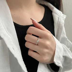 Detailed view of an s925 sterling silver six-prong round zircon ring worn on a finger