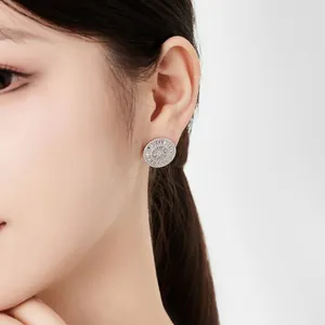 Detail of round S925 silver stud earrings with baguette-cut cubic zirconia on ear