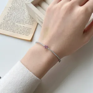 Nahaufnahme eines S925-Silberarmbands mit rosa Herz-Edelstein getragen am Handgelenk