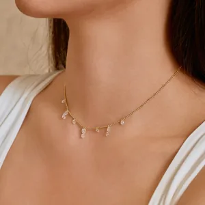 Detail of S925 silver necklace with dangling zircon crystals on gold-tone bead chain