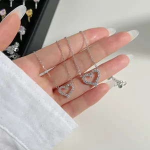 Collier cœur en argent S925 serti de zircons tenu à la main pour l'échelle