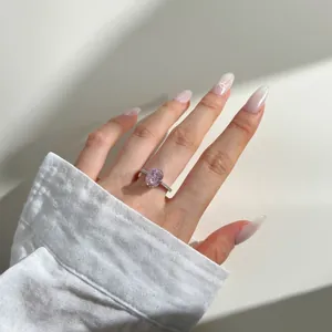 Macro detail of oval pink gemstone ring with pavé diamonds on a silver band