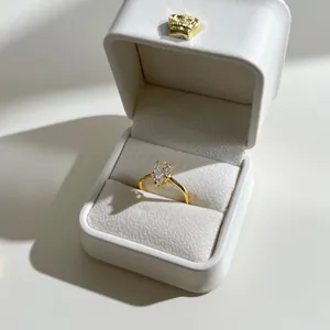 Macro view of pear-cut sparkling zircon ring inside a luxury white velvet jewelry box