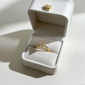 Pear cut pink stone ring in gold finish presented in a white crown jewelry box