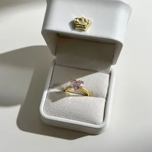 Pink heart-shaped gemstone ring in a premium white crown gift box with gold band detail