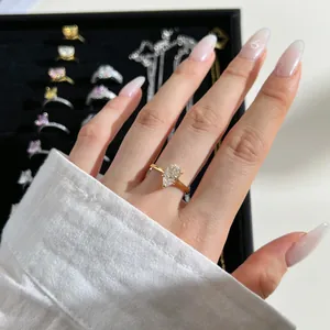 Close-up of a gold ring featuring a pear-cut zircon on a finger in a jewelry box