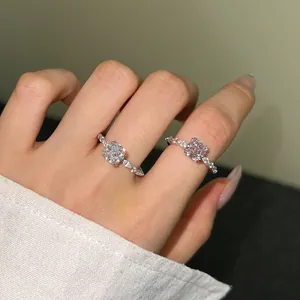 Close-up van S925 zilveren ringen met vierkante roze en witte stenen op een hand