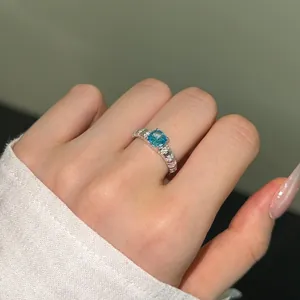 Close-up of 925 sterling silver ring with square blue gemstone and side diamonds