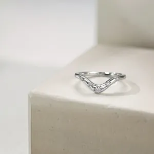 Close-up of polished V-shaped 925 silver ring with five sparkling zircon stones on stone