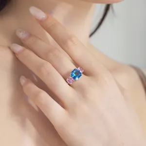Elegante anillo de plata S925 con circonitas cuadradas azules y rosas puesto en mano