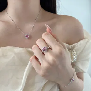 Close-up of pink heart-shaped zircon necklace, ring and bracelet set on a female model