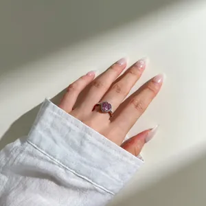 Detailed view of a heart-shaped pink zircon ring with a diamond halo on a silver band