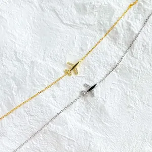 Dettaglio di collane ad aereo in oro e argento con zirconi scintillanti incastonati