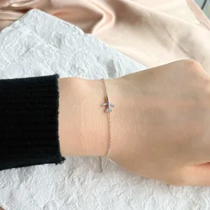 Dettaglio del bracciale in argento S925 con ciondolo aereo e zirconi indossato al polso