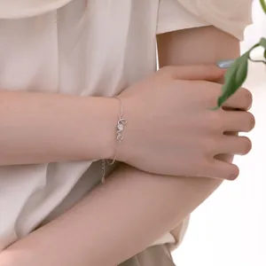 Détail du bracelet Love en argent S925 avec breloque cœur pavé sur un poignet féminin