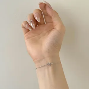 Dettaglio del bracciale con aereo in argento sterling e zirconi indossato al polso