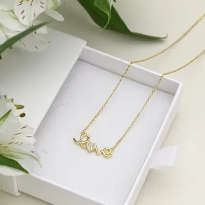 Detailed view of a gold S925 silver love necklace with heart zircon in a gift box