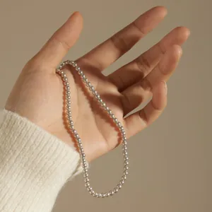 Elegant S925 sterling silver bead necklace held in hand with a minimalist French style