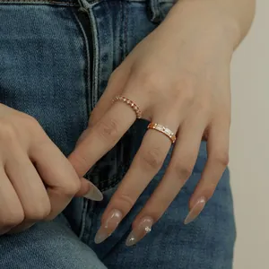 Detail showing stacked rose gold rings with V-shape diamonds and emerald cut stones