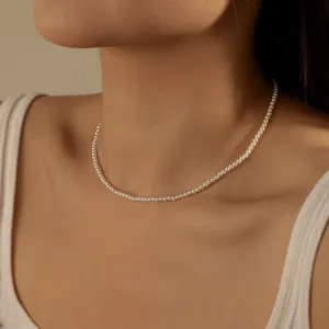 Close-up of minimalist S925 silver necklace with small white pearls on a model's neck