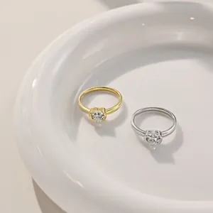Macro shot of silver and gold heart rings with marquise zircon on a white plate