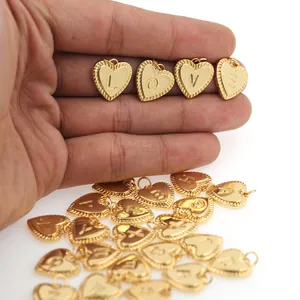 Macro shot of 18K gold plated heart charms with letter engravings for DIY necklaces