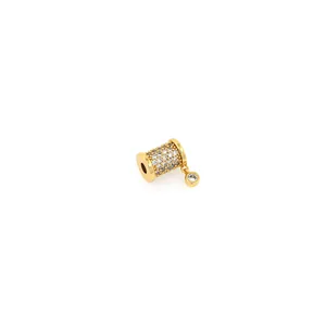 Dettaglio macro di perla a botte placcata oro 18K con micro-pavé di zirconi e pietra pendente